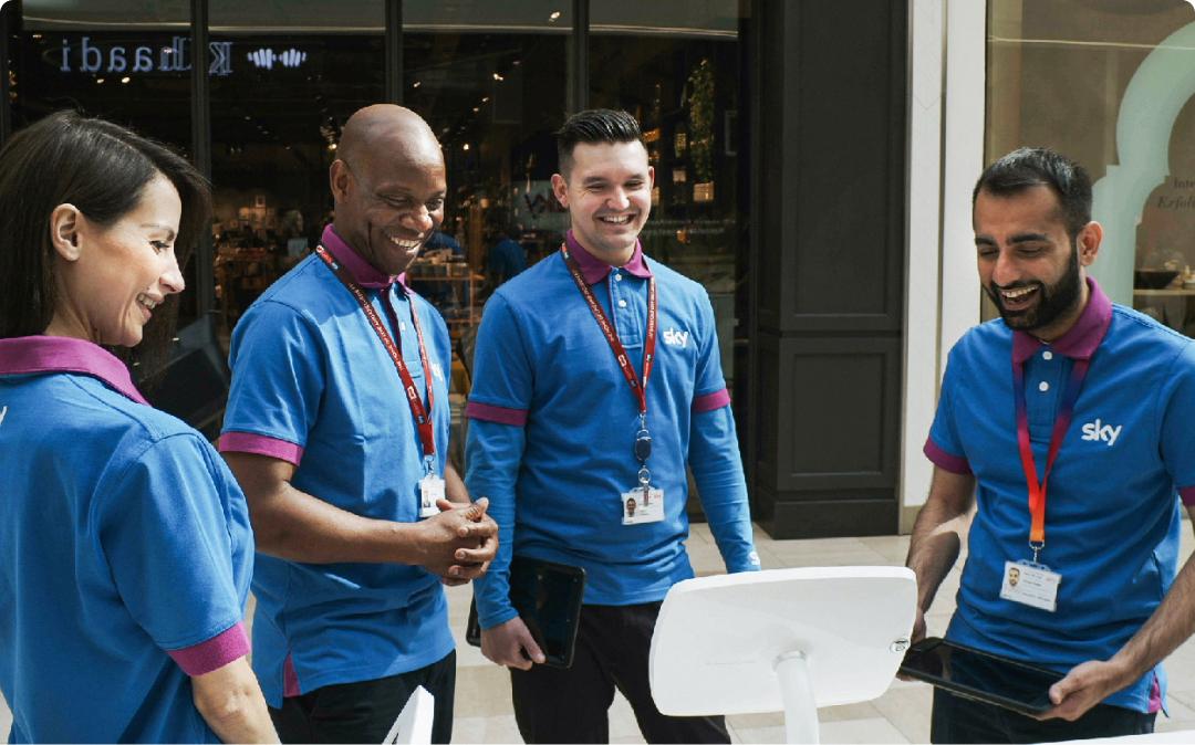 Image of 4 men who work for Sky stood around a tablet.