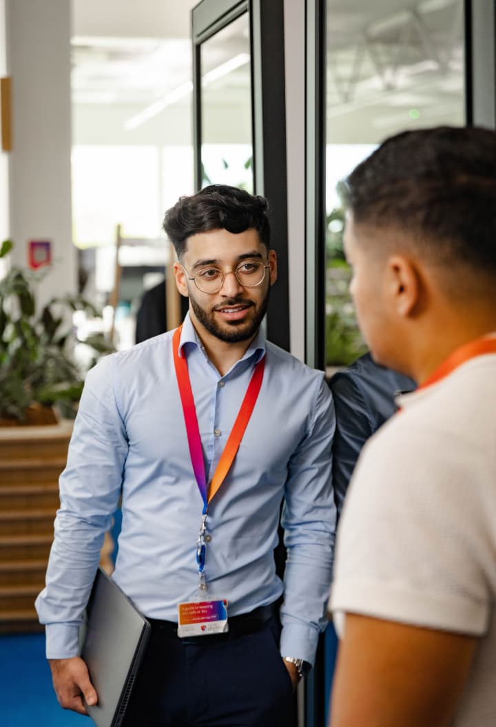 two men conversing outside a meeting room