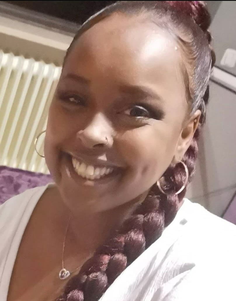 A selfie picture of Sadiya, in front of a home-office setup.